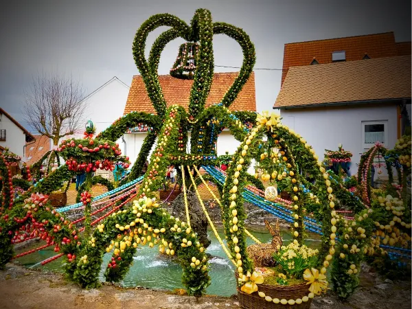 Easter fountain decorated with tree branches, eggs, and ribbons